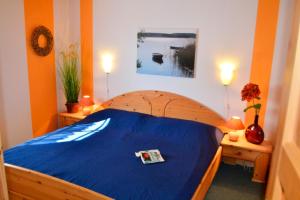 乌塞林Haus Vogelsang的一间卧室配有一张带蓝色床单的木床