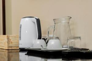 帕拉佩Pahotela Bed and Breakfast的咖啡壶和桌子上的两个杯子