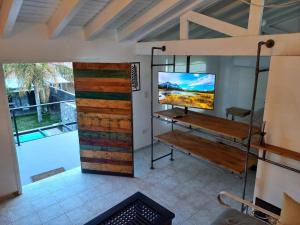 门多萨H125 - Complejo Mendoza的一间设有木门的墙上电视的房间