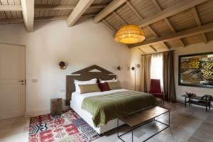 莱切Palazzo Maresgallo Suites & SPA的一间卧室配有一张大床和一个吊灯。