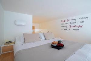 波托菲诺Wanderlust by PortofinoHomes的一间卧室,配有一张床,上面放着一碗水果