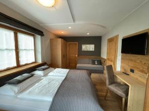 韦尔图尔诺莫亚里霍夫酒店的一间卧室配有一张床、一张书桌和一台电视
