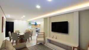 伊瓜苏Apartamento completo - Vila A的客厅配有桌子和墙上的电视