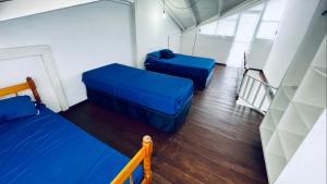 邦比尼亚斯Residencial Morro Macaco Apartamentos的一间设有两张蓝色床铺和楼梯的房间