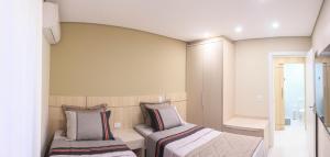 伊瓜苏Apartamento completo - Vila A的一间卧室设有两张床和窗户。