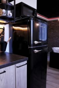 纳尔瓦Narva City的厨房配有黑色冰箱,配有微波炉