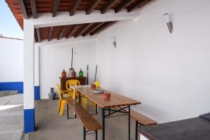 CampinhoA Janela do Alentejo的一间带木桌和黄色椅子的用餐室