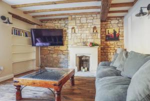 奇平卡姆登Grooms Lodge, Chipping Campden - Taswell Retreats的带沙发和壁炉的客厅