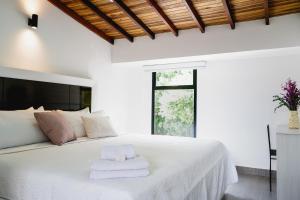 库库塔Hotel Casa Luna的卧室配有白色床和毛巾