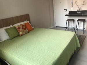 里约热内卢Fantástico STUDIO DIVISA COPACABANA IPANEMA REFORMADO E DECORADO的一间卧室配有一张带绿毯的床