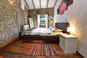 莫托文Villa Luna的一间卧室设有一张床和石墙