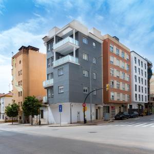 马拉加AAC Málaga - Apartamento muy cómodo y bien comunicado, a 1,3km del centro的一条城市街道上高大的灰色建筑