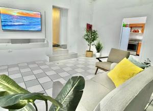 圣胡安Oasis Inn的客厅配有沙发和墙上的电视