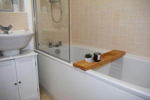 马斯顿格林Modern 2 Bed house - HS2, NEC & Birmingham Airport的浴室配有水槽、浴缸和水槽