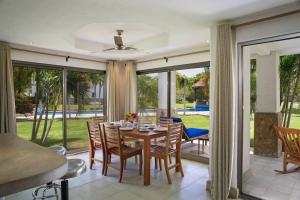 里瓦斯Golf Condo A1 F1: Nice view and access to the largest pool in Hacienda Iguana!的用餐室配有桌椅和滑动玻璃门