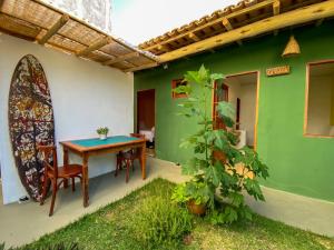 卡拉伊瓦Pousada Tamikuã的一个带桌椅和绿色墙壁的庭院