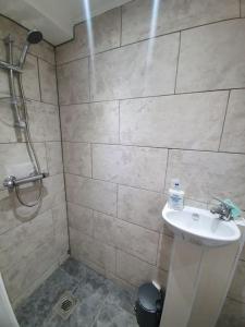 达格纳姆5 Bedroom House by monishortlets的浴室配有白色水槽和淋浴。