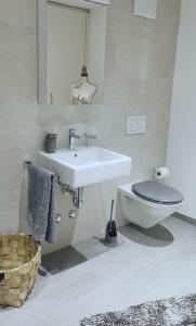 库尔La Suite的白色的浴室设有卫生间和水槽。
