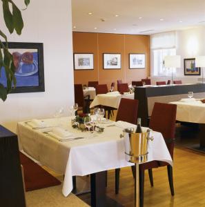 塞斯豪普特阿尔特波斯特塞瑞思德酒店的用餐室配有带白色桌布的桌子