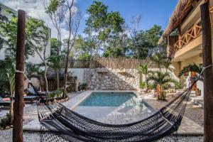 图卢姆Aldea San Lam - Oasis Of Tulum的房屋前的吊床,带游泳池