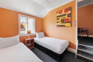 肯图巴Hotel Blue & Cottages Katoomba的酒店客房设有两张床和窗户。