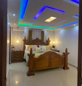 圣地亚哥洛斯卡巴VIP Home的一间卧室设有一张大木床和蓝色的天花板