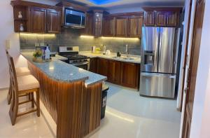 圣地亚哥洛斯卡巴VIP Home的厨房配有木制橱柜和不锈钢冰箱。