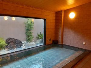 龟山龟山间路线酒店的一座房子里一个带鱼缸的游泳池