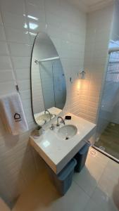 桑托斯Apartamento encantador em prédio histórico的一间带水槽和镜子的浴室