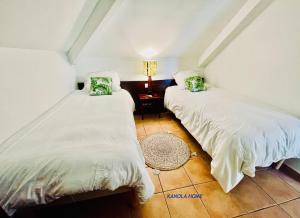 圣安尼KANOLA Home的两张睡床彼此相邻,位于一个房间里