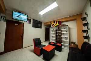 瓦努科HOSTAL TARAPACA的一间设有椅子、电视和门的等候室