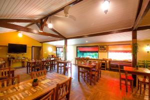 米格尔-佩雷拉ECO RESORT FASCINAÇÃO的餐厅设有木桌、椅子和电视