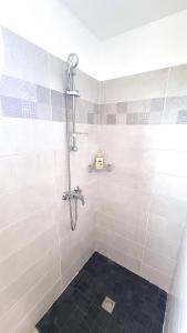 法兰西堡Le Marie-Agnès Appartement neuf de Standing的浴室铺有黑色瓷砖地板,设有淋浴。