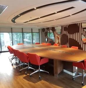 万隆B Landmark Residence的一间会议室,配有大桌子和椅子