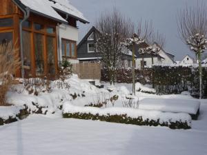 埃斯洛黑Apartment in Eslohe with terrace的房子前面的雪堆积的院子