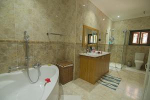拉迪格岛Pension Michel Villa Roche Bois的带浴缸和盥洗盆的浴室