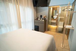 新加坡Hotel Bencoolen at Hong Kong Street的一间带白色床的卧室和一间浴室
