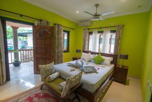 拉迪格岛Pension Michel Villa Roche Bois的一间卧室设有一张带绿色墙壁和窗户的床。
