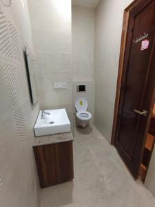 齐拉克普尔Hotel kartik的浴室配有白色水槽和卫生间。