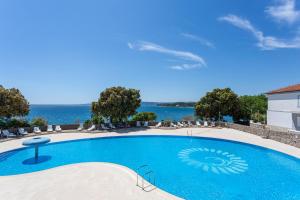 克尔克Villa Lovorka - Hotel Resort Dražica的一座背景海洋的游泳池
