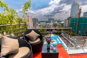 胡志明市Roseland Sweet Hotel & Spa的阳台配有桌椅,享有城市美景。