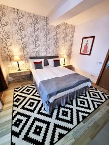 CristeştiMotel Via Targu Mures的卧室配有床和黑白地毯。