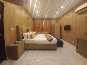 拉合尔Premier Inn Johar Town Lahore的一间酒店客房,配有一张床和一台电视