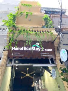 河内Hanoi EcoStay 2 hostel的植物建筑的一侧的标志