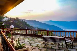 潘奇加尼Sharayu Holidays Valley View的阳台设有长凳,享有水景