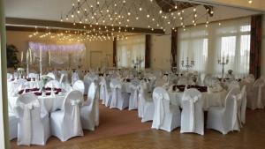 埃斯彭瑙瓦尔德斯艾弗贝格酒店的宴会厅配有白色的桌椅和吊灯