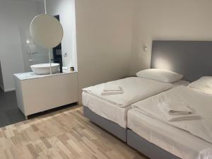 利贝雷茨布拉格利贝雷茨酒店的一间卧室设有两张床、一个水槽和镜子