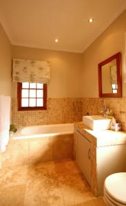 弗朗斯胡克Cabriere Cottage的带浴缸、盥洗盆和卫生间的浴室