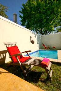 弗朗斯胡克Cabriere Cottage的游泳池旁的红色椅子