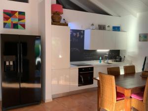 威利布罗德Villa 13, Coral Estate的厨房配有黑色冰箱和桌子